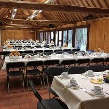 Patio Arboretum Kalmthout, feestelijke gedekte tafel onder een lindenboom. Links de Foyer met serre en het dak van de Balkenzaal.