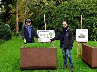 Jan De Haes, gedeputeerde van de provincie Antwerpen, en Abraham Rammeloo, conservator-directeur van Arboretum Kalmthout, staan bij twee cortenstalen verhoogde plantenbakken van één vierkante meter bij de presentatie van de campagne Word meter of peter van een vierkante meter in Arboretum Kalmthout.